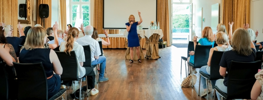 Moderatorin Sabine Ziemke im vollen Saal